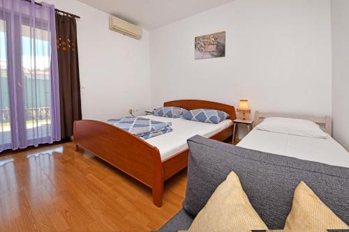 ein Schlafzimmer mit zwei Betten und einem Fenster in der Unterkunft Apartments Dulabic in Poreč