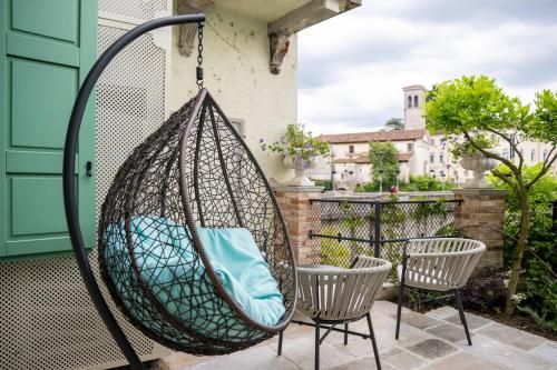 a hammock on a patio with two chairs and a table at 1448 Antica Dimora Al Merlo Bianco in Cividale del Friuli