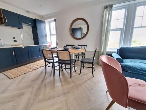 a living room with a table and chairs and a blue couch at Victorian Villa, Hunstanton Norfolk Sleeps 20 in Hunstanton