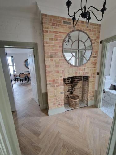 a brick fireplace with a clock on a wall at Victorian Villa, Hunstanton Norfolk Sleeps 20 in Hunstanton