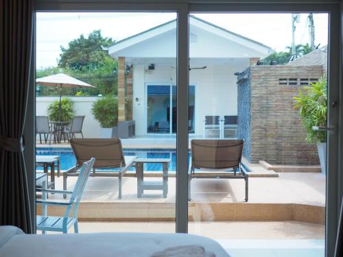 a view of a patio with chairs and a table at Mangoes Pattaya in Na Jomtien