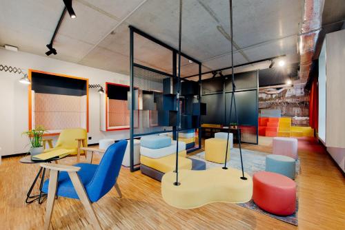 a room with colorful chairs and a table at MILESTONE by Tribera Gdańsk Center in Gdańsk