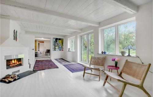 a living room with a fireplace and a table and chairs at Gorgeous Home In Rødby With Wifi in Rødby
