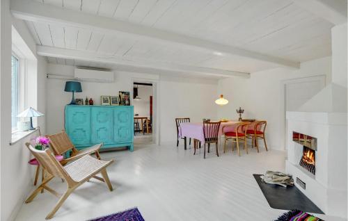 a living room with a table and chairs and a fireplace at Gorgeous Home In Rødby With Wifi in Rødby