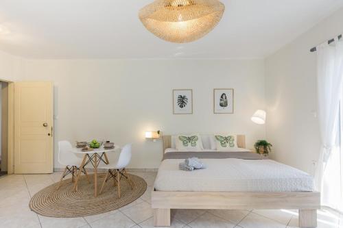a bedroom with a bed and a table and a chandelier at Beyond in Argostoli