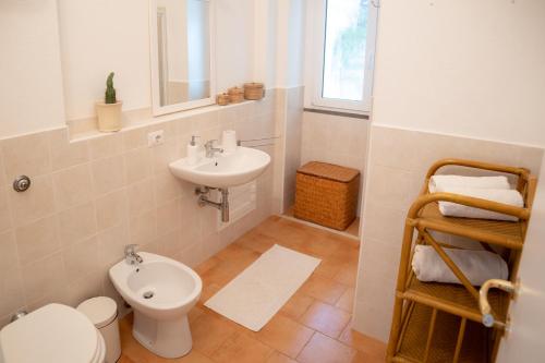 a bathroom with a toilet and a sink at Il Casale in Teulada