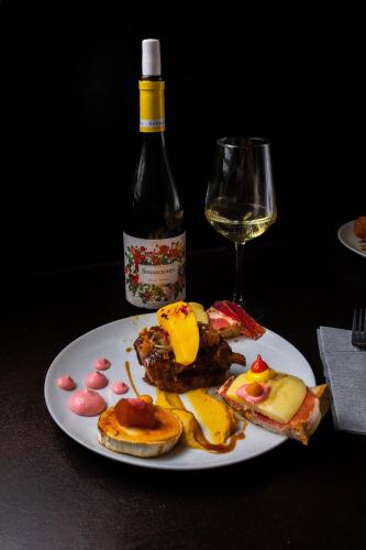 a white plate with food and a bottle of wine at Hostal Alto Aragon in Villanúa