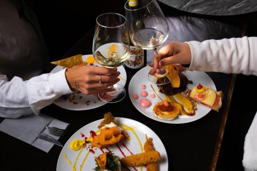 two people sitting at a table with plates of food at Hostal Alto Aragon in Villanúa