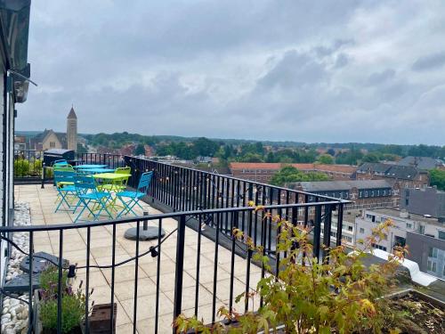 a balcony with two chairs and a table on it at Skylodgenk in Genk