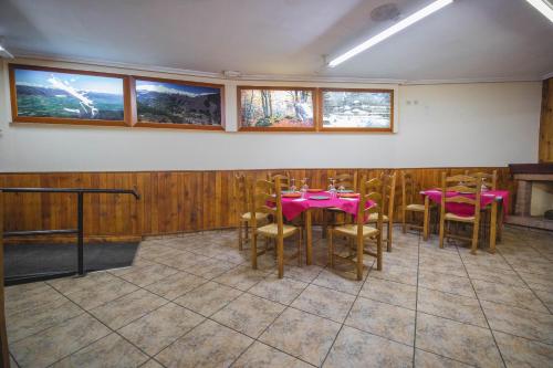 a dining room with pink tables and chairs at Hostal Alto Aragon in Villanúa