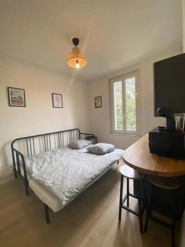 une chambre avec un lit, une table et une fenêtre dans l'établissement Studio confortable au centre de Vichy 15 m² avec Wi-Fi, à Vichy