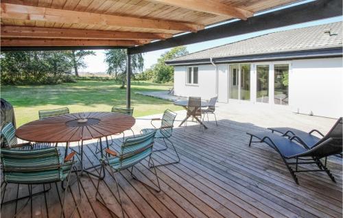 a patio with a table and chairs on a deck at Awesome Home In Samsø With Sauna in Nordby