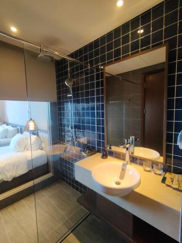 a bathroom with a sink and a mirror and a bed at Apec Mandala Chambay Mũi Né in Ấp Thiẹn Ái
