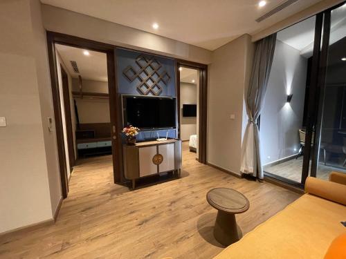 a living room with a flat screen tv and a stool at Apec Mandala Chambay Mũi Né in Ấp Thiẹn Ái