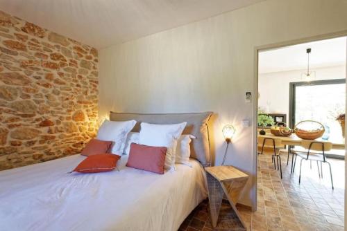 une chambre avec un lit avec des oreillers dessus dans l'établissement Villa Cinsault, un bijou pour votre séjour en Provence Verte, à La Celle