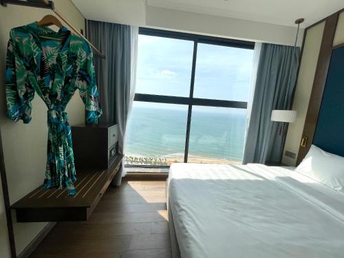 a hotel room with a bed and a large window at Apec Mandala Chambay Mũi Né in Ấp Thiẹn Ái