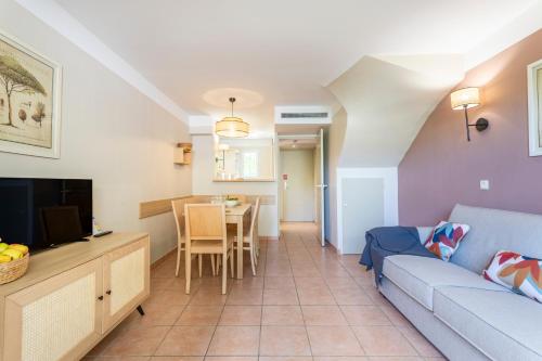 a living room with a couch and a table at Résidence Pierre & Vacances le Hameau de la Pinède in Hyères