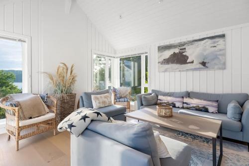 a living room with blue couches and a table at Sommerhus ved Iddefjorden in Halden