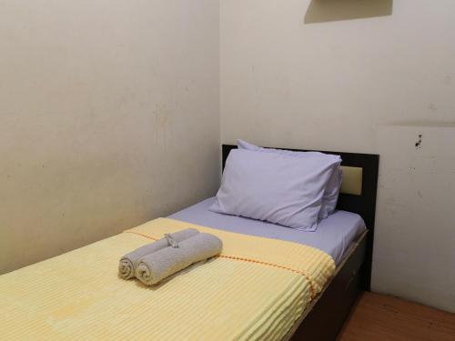 a bed with a pillow and a towel on it at Cibubur Village By Arsakha Property Management in Cibubur