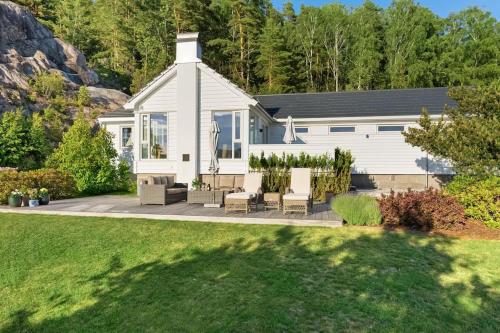 a white house with a lawn in front of it at Sommerhus ved Iddefjorden in Halden