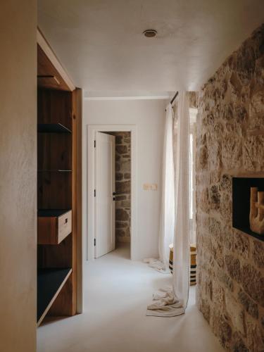 a room with a stone wall and a hallway at Palazzo Caterina in Hvar