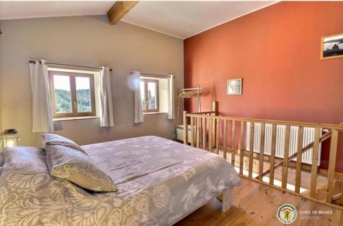 a bedroom with orange walls and a bed and a staircase at Grange De Sagne maison et table d hôtes avec dîner sur réservation in Saint-Jean-Roure