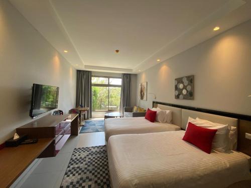 ベイルートにあるThe Ray Hotel and Studiosのベッド2台とテレビがあるホテルの部屋