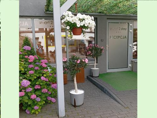 a store with potted plants and flowers in front of it at Smart2Stay Magnolia in Warsaw