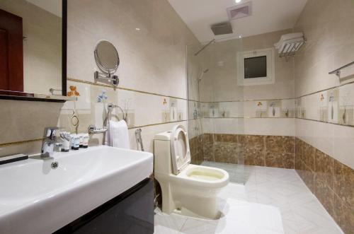 a bathroom with a white sink and a toilet at Mora Hotel in Al Khobar