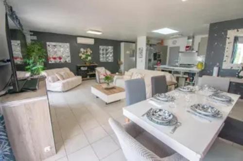 un salon avec une table et une cuisine dans l'établissement Maison de charme avec piscine privée à Grasse, à Grasse