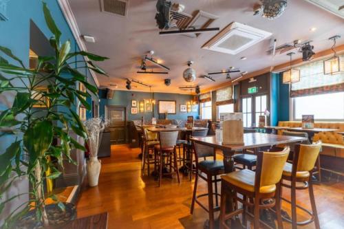 a restaurant with tables and chairs in a room at OYO The Red Lion Hotel in Luton