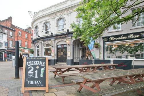 a couple of picnic tables in front of a building at OYO The Red Lion Hotel in Luton
