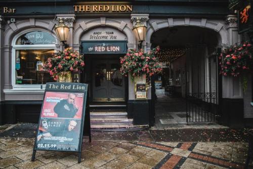 a red lion building with a sign in front of it at OYO The Red Lion Hotel in Luton
