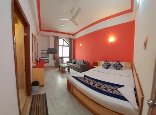 a bedroom with a bed with a red wall at Hotel Indore Palace - Newly Renovated Hotel in Shirdi