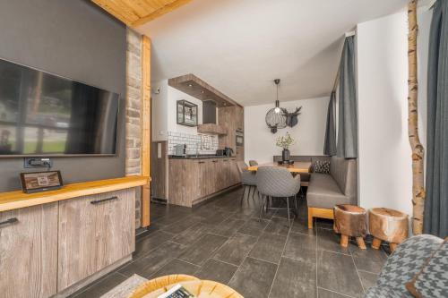 a living room with a television and a table at AvenidA Panorama Suites in Kaprun