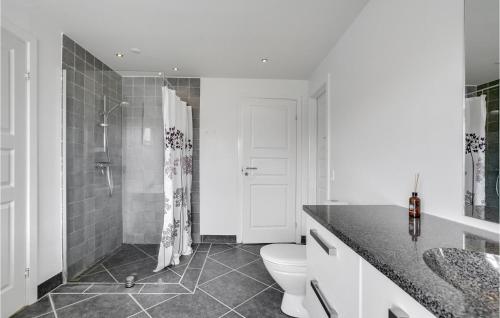 a white bathroom with a toilet and a shower at Holiday Home Børkop With Hot Tub Xiv in Børkop