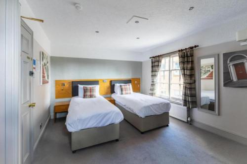 a bedroom with two beds and a window at OYO The Red Lion Hotel in Luton