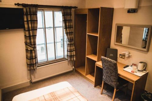 a small room with a desk and a window at OYO The Red Lion Hotel in Luton