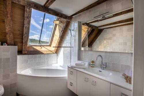 a bathroom with a tub and a sink at Chez Mimi - La Petite Maison in Raulhac