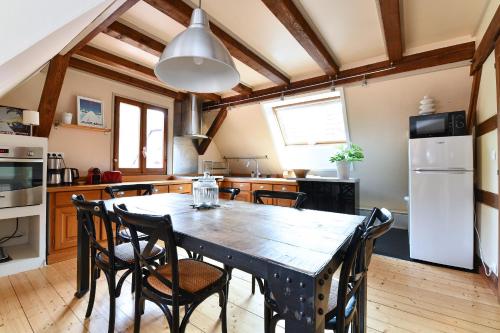 une cuisine avec une table et des chaises en bois dans l'établissement Appartement Gaspard & Lilly avec Balcon, à Kaysersberg