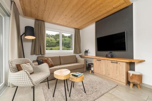 a living room with a couch and a tv at AvenidA Panorama Suites in Kaprun