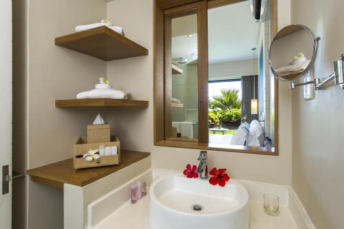 a bathroom with a sink and a mirror at Radisson Blu Poste Lafayette Resort & Spa (Adults Only) in Poste Lafayette