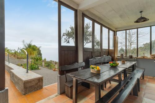 a dining room with a wooden table and benches at Sa Dias House by AH in São Jorge