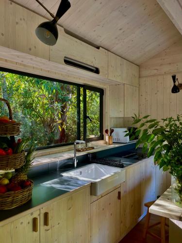 a kitchen with a sink and a large window at Resort & Glamping Terre di Sacra in Toscana in Capalbio