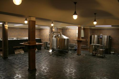 a large room with a kitchen with tanks and lights at Hotel Purkmistr in Plzeň
