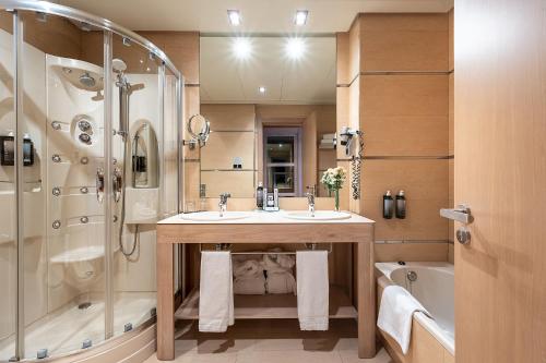 a bathroom with a sink and a shower and a tub at Hotel Nelva in Murcia