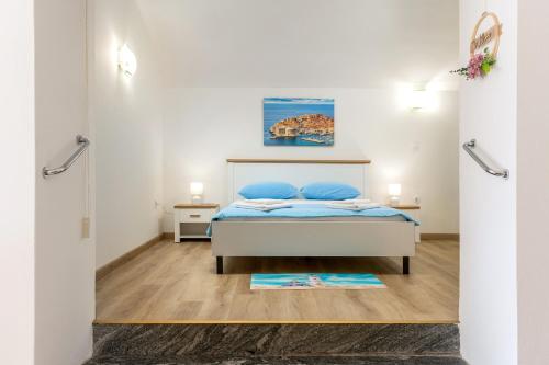a bedroom with a bed with blue pillows at Beach Apartment Francesko near Old Town in Dubrovnik