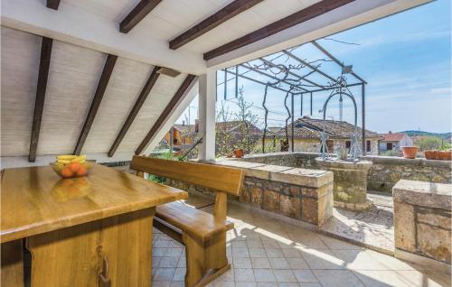 an outdoor patio with a wooden bench and a table at Two-Bedroom Apartment In Vrsar in Vrsar