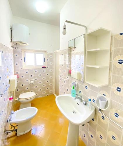 a white bathroom with a toilet and a sink at Il Foscolo in Torre dell'Orso
