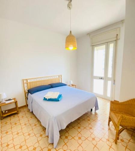 a bedroom with a bed and a chair and a window at Il Foscolo in Torre dell'Orso